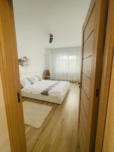 a bedroom with two beds and a door open at Apartament YRA Rm.Valcea in Râmnicu Vâlcea