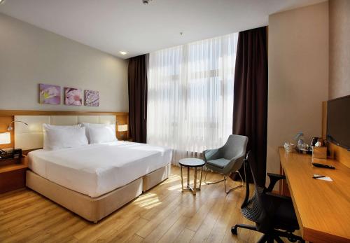 una camera d'albergo con letto, scrivania e computer di Hilton Garden Inn Kocaeli Sekerpinar a Şekerpınarı