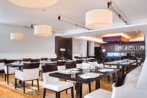 a restaurant with black tables and white chairs at Hilton Garden Inn Venice Mestre in Mestre