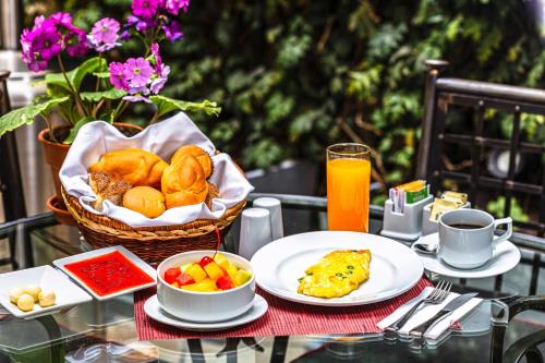 una mesa con platos de comida y una cesta de comida en LP Los Portales Hotel Cusco, en Cusco