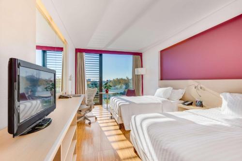 a hotel room with two beds and a flat screen tv at Hilton Garden Inn Venice Mestre in Mestre