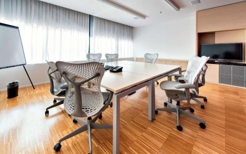 a conference room with a table and chairs and a screen at Hilton Garden Inn Venice Mestre in Mestre