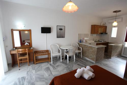 a kitchen and a living room with a table and chairs at Archontiko Driani in Paralia Panteleimonos