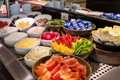 a buffet filled with bowls of different types of food at Doubletree by Hilton Vienna Schonbrunn in Vienna