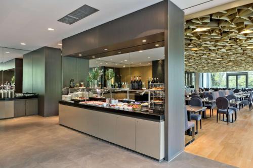a restaurant with a buffet line with tables and chairs at Doubletree by Hilton Vienna Schonbrunn in Vienna