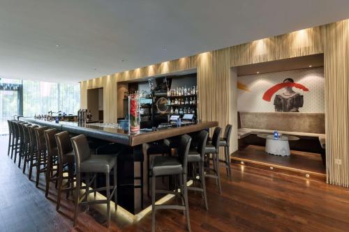 a bar in a restaurant with a bunch of chairs at Doubletree by Hilton Vienna Schonbrunn in Vienna