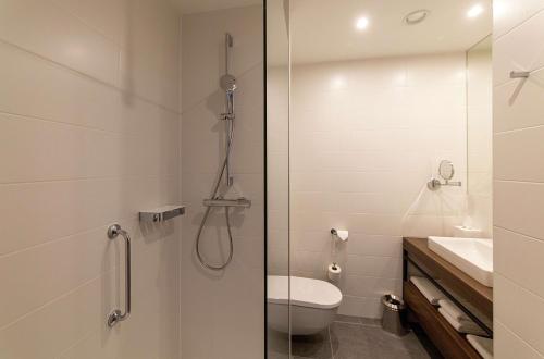 a bathroom with a shower and a toilet and a sink at Hilton Garden Inn Zagreb - Radnička in Zagreb