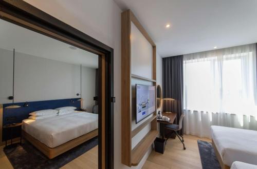 a hotel room with a bed and a mirror at Hilton Garden Inn Zagreb - Radnička in Zagreb