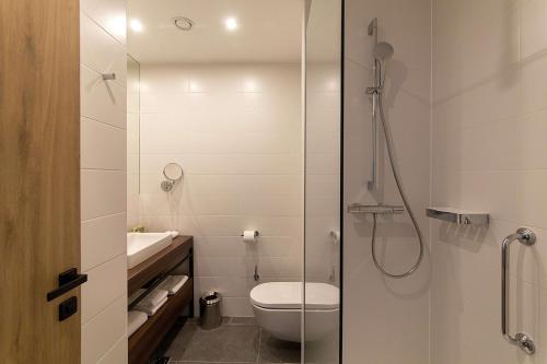 a bathroom with a shower and a toilet and a sink at Hilton Garden Inn Zagreb - Radnička in Zagreb