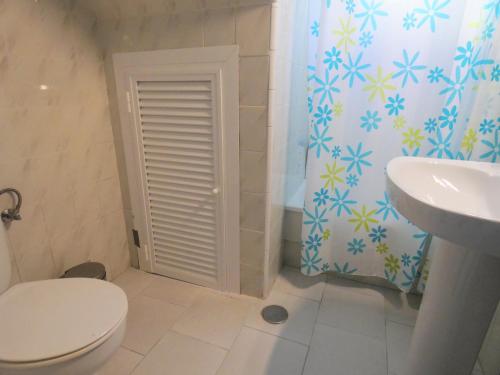 a bathroom with a toilet and a sink at Chalet primera línea, La Barrosa in Chiclana de la Frontera