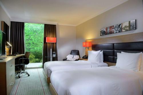 a hotel room with two beds and a television at Hilton Zurich Airport in Opfikon