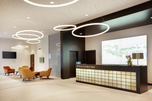 ein Wartezimmer mit Stühlen und einer Präsentation auf einem Bildschirm in der Unterkunft Hilton Garden Inn Zurich Limmattal in Spreitenbach