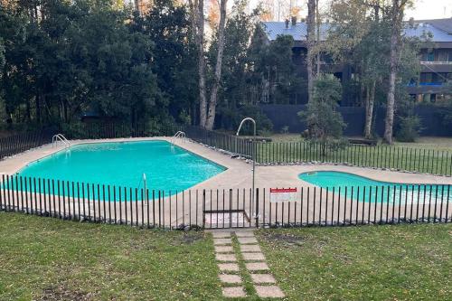 una piscina con una valla alrededor en hermoso departamento 1 dormitorio en entorno natural, en Pucón