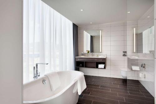 y baño con bañera, lavabo y aseo. en Hilton Garden Inn Zurich Limmattal, en Spreitenbach