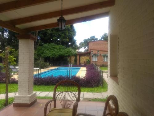 patio z 2 krzesłami i basenem w obiekcie Casas Río Molle w mieście Yerba Buena