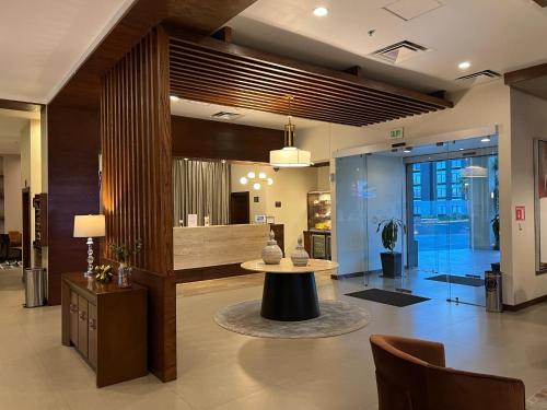 a lobby with a table in the middle of a room at Best Western Plus Chihuahua Juventud in Chihuahua