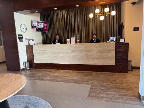 three people sitting at a reception counter in a lobby at Best Western Plus Chihuahua Juventud in Chihuahua