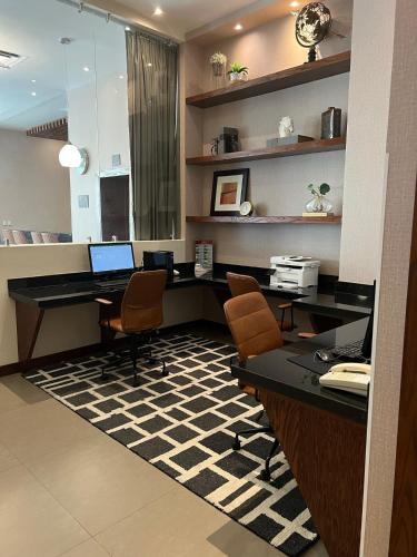 an office with a desk with a laptop and two chairs at Best Western Plus Chihuahua Juventud in Chihuahua
