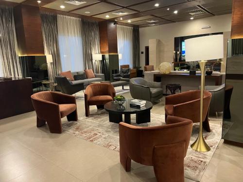 a lobby with chairs and a table and a living room at Best Western Plus Chihuahua Juventud in Chihuahua