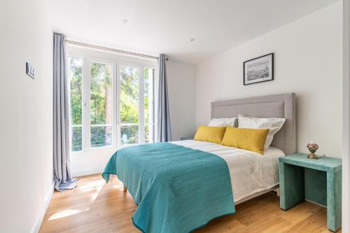 een witte slaapkamer met een bed en een raam bij SUCY in Chennevières-sur-Marne