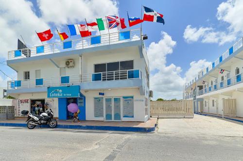 a building with many flags on the side of it at Costa Love Hotel Aeropuerto in Punta Cana