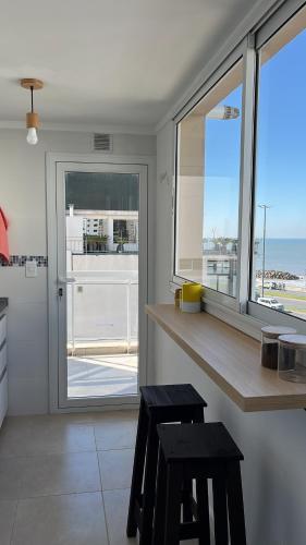 a kitchen with a counter and a view of the ocean at Excelente! 4 personas frente al mar con cochera in Mar del Plata