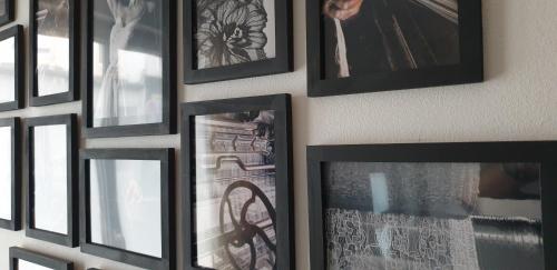 Une bande de photos encadrées accrochées à un mur dans l'établissement Maison à deux pas de l'hôtel de ville, à Calais