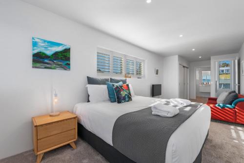 a bedroom with a large bed and a chair at Linger Lakeside in Taupo