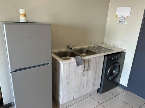a kitchen with a sink and a washing machine at Hidden gem with gorgeous sunsets - One on Heather in Midrand