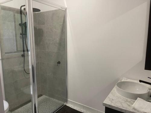 a bathroom with a glass shower and a sink at Milton House, Hamilton in Hamilton