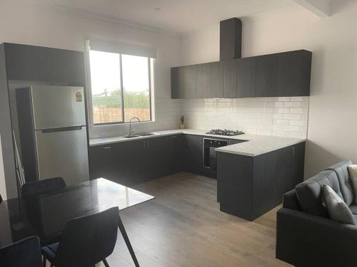 a kitchen with a refrigerator and a table in a room at Milton House, Hamilton in Hamilton