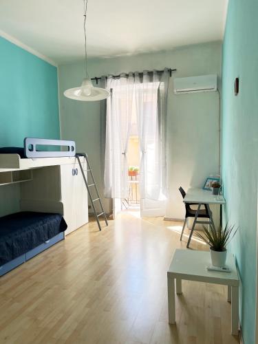 a room with a bed and a table and a desk at Mariamora Apartment in Bari