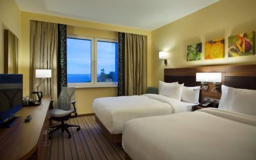 ein Hotelzimmer mit 2 Betten und einem Schreibtisch in der Unterkunft Hilton Garden Inn Ufa Riverside in Ufa