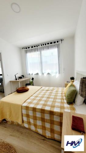 a bedroom with a large bed with a checkered blanket at Apartament a Sant Celoni, Montseny, Barcelona in San Celoni
