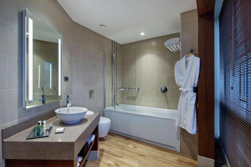 a bathroom with a sink and a toilet and a tub at Hilton Garden Inn Corlu in Corlu