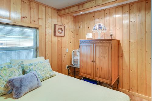 1 dormitorio con 1 cama y pared de madera en Satsuma Vacation Rental with Dunns Creek Access en Satsuma