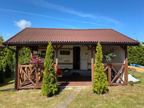 una pequeña casa con una puerta y una caravana en Tropikalny Zakątek, en Sarbinowo