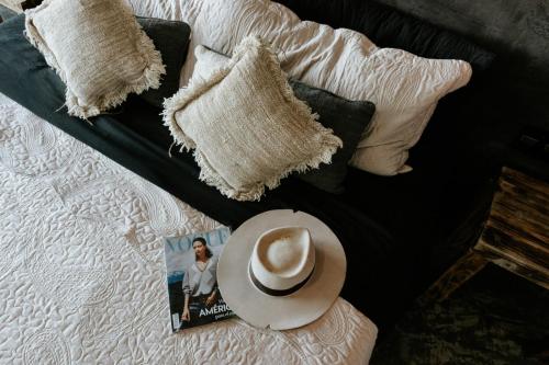 a hat sitting on top of a bed with pillows at Luxury Villa Ocean View "Casa Mar" in Holbox Island
