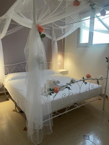 un letto con baldacchino bianco e fiori di Dimora Agnese a Casalabate