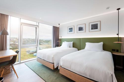 una camera d'albergo con due letti e una finestra di Hilton Garden Inn Faroe Islands a Tórshavn