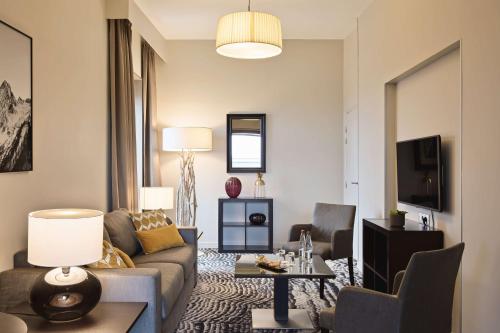 a living room with a couch and a table at DoubleTree by Hilton Lyon Eurexpo in Saint-Priest