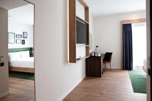 a bedroom with a bed and a television on a wall at Hilton Garden Inn Munich Messe in Feldkirchen