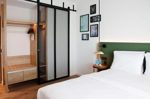 a bedroom with a bed and a walk in shower at Hilton Garden Inn Munich Messe in Feldkirchen