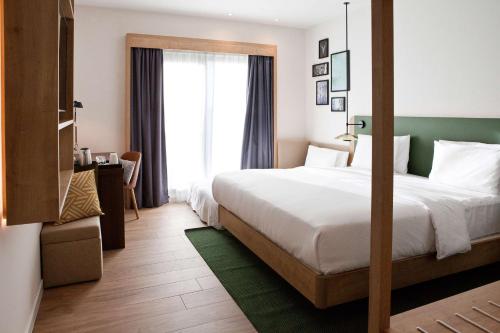 a hotel room with a large bed and a window at Hilton Garden Inn Munich Messe in Feldkirchen
