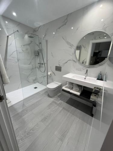 a bathroom with a shower and a toilet and a sink at M & A apartamentos turísticos in Salamanca