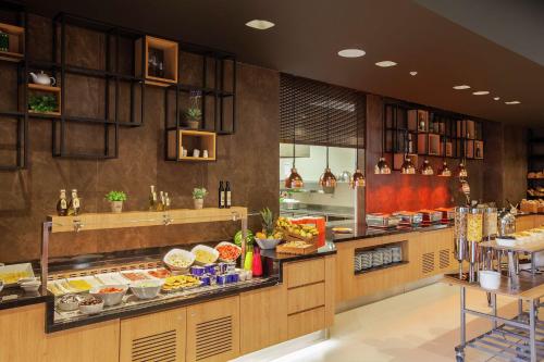 Hilton Garden Inn Tirana في تيرانا: مطعم يقدم بوفيه مع الطعام