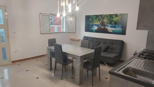 a kitchen and living room with a table and a couch at Dimora Agnese in Casalabate
