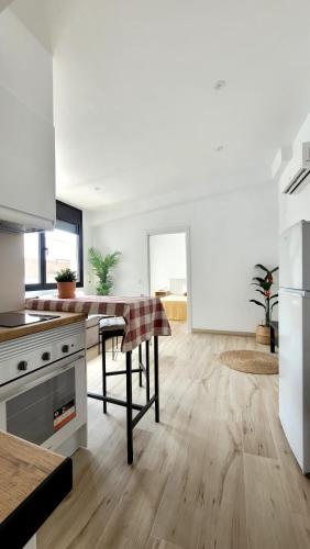 a kitchen with white walls and a wooden floor at Apartament a Sant Celoni, Montseny, Barcelona in San Celoni