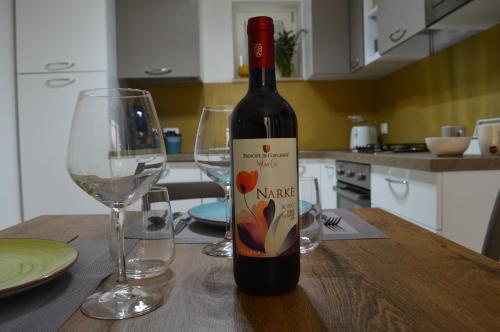 a bottle of wine sitting on a table with two glasses at Futtitinni Home casamia in Palermo