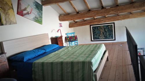 1 dormitorio con 1 cama y suelo de madera en Opera d'Oro, en Piegaro
